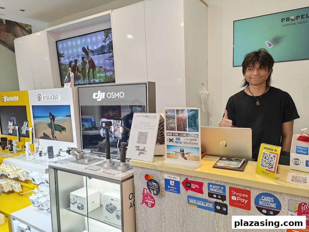 An interior view of Propeller Singapore, showcasing action cameras, drones, and a friendly staff member.