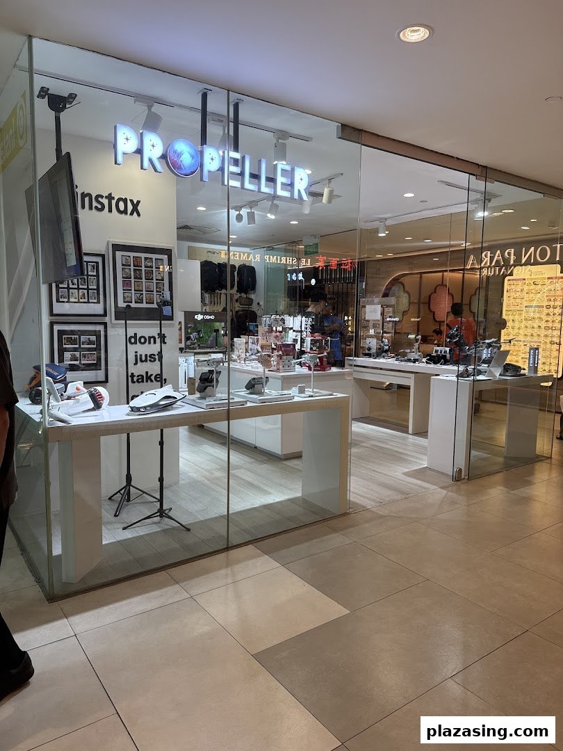 The brightly lit storefront of Propeller Singapore, showcasing modern tech gadgets and accessories through its glass display.
