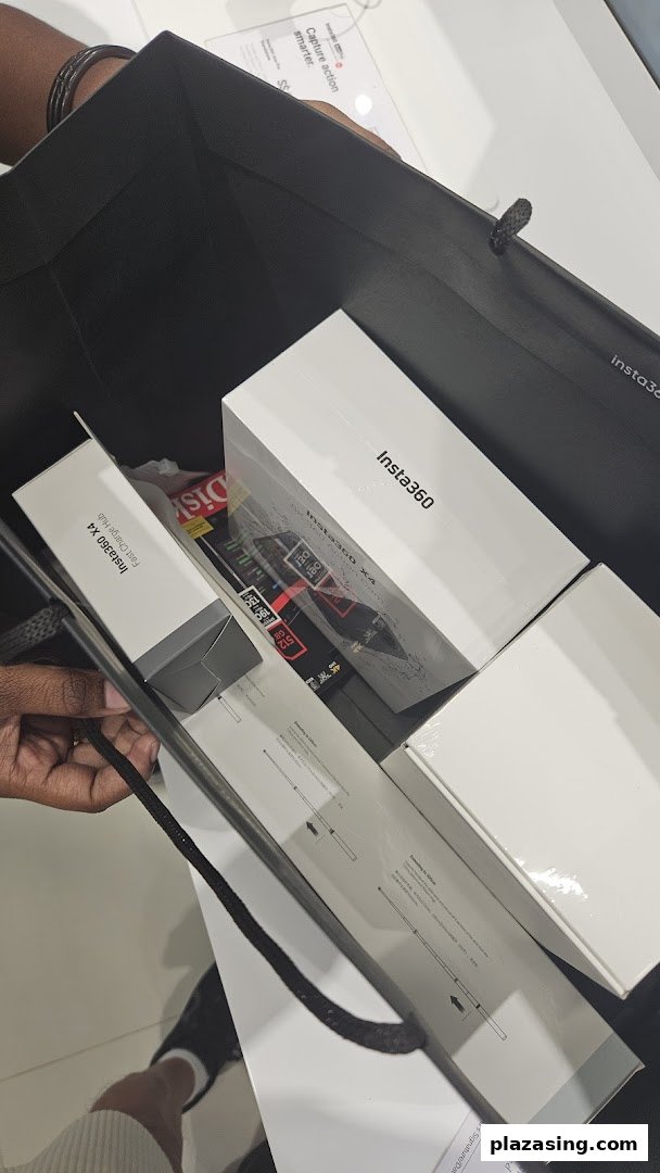 A shopping bag filled with new Insta360 X4 cameras and accessories, held by a customer.