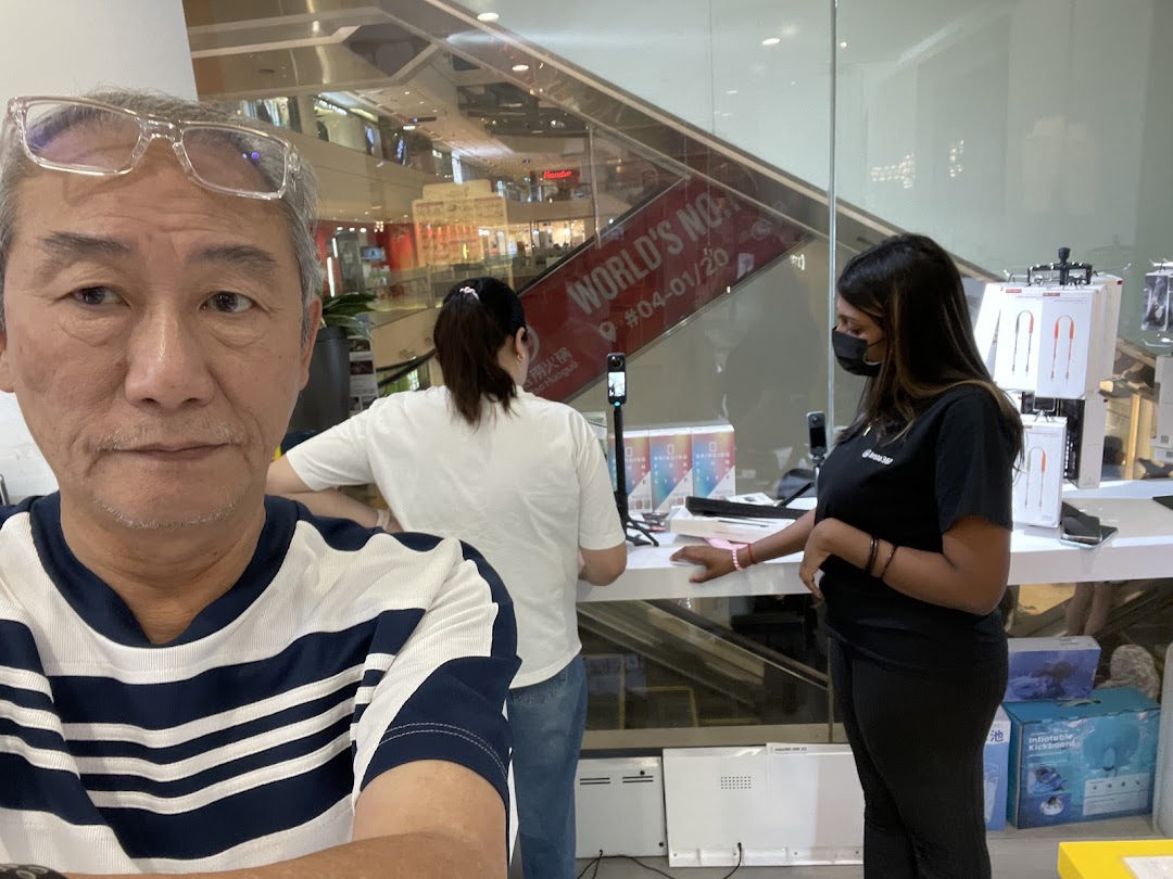 A customer's selfie inside Propeller Singapore, showcasing staff and various tech products on display.