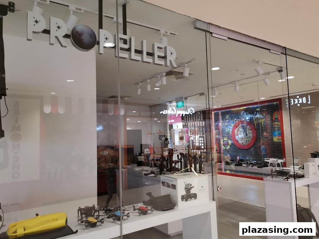 The glass storefront of Propeller Singapore, showcasing drones and tech products in its display window.