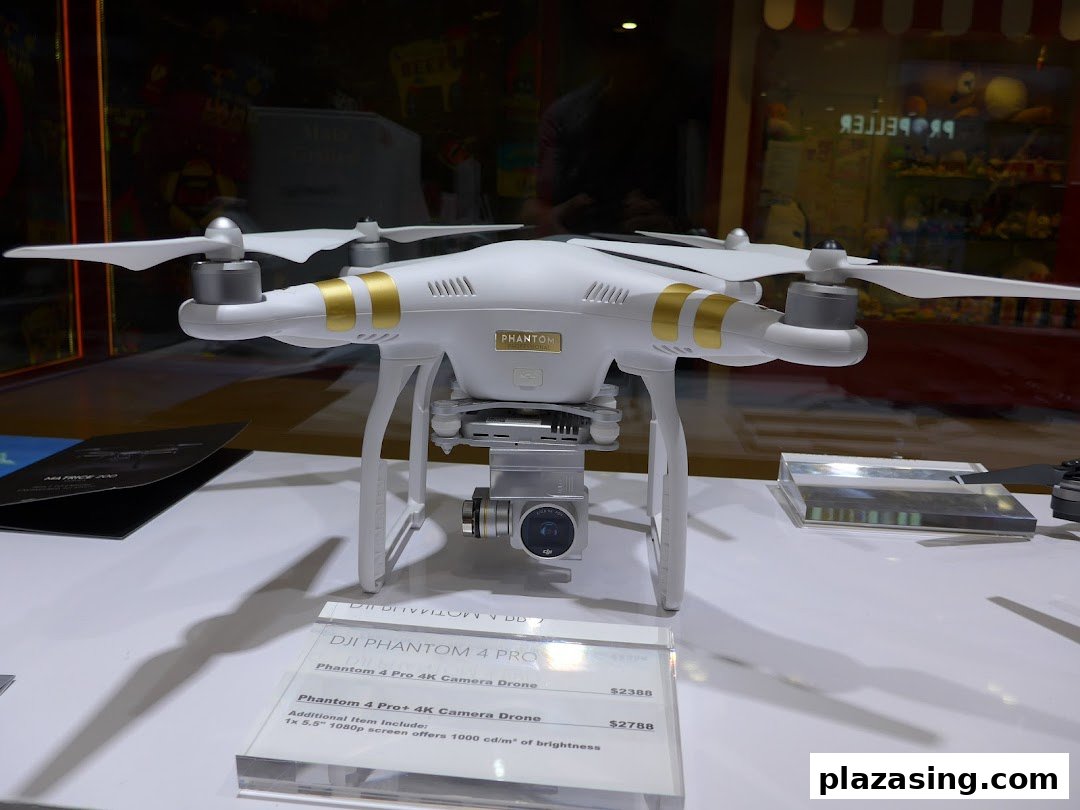 A white DJI Phantom drone is showcased on display with pricing details in a retail setting.