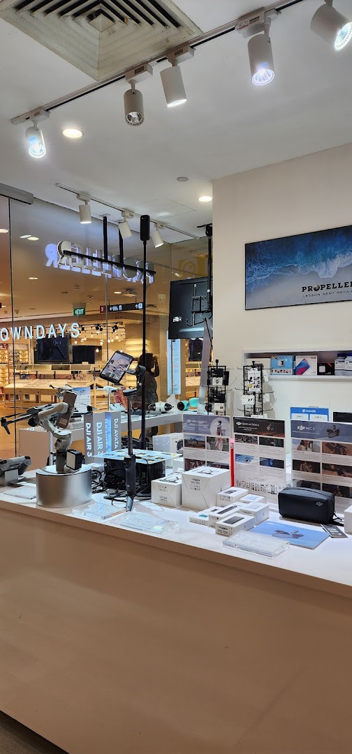 An interior view of Propeller Singapore, showcasing DJI drones, gimbals, and camera accessories on display.