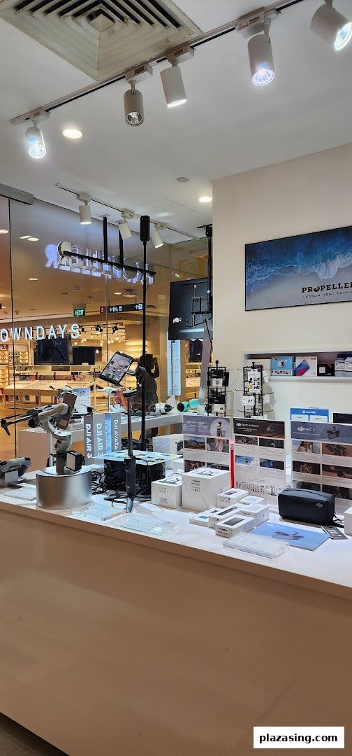 An interior view of Propeller Singapore, showcasing DJI drones, gimbals, and camera accessories on display.