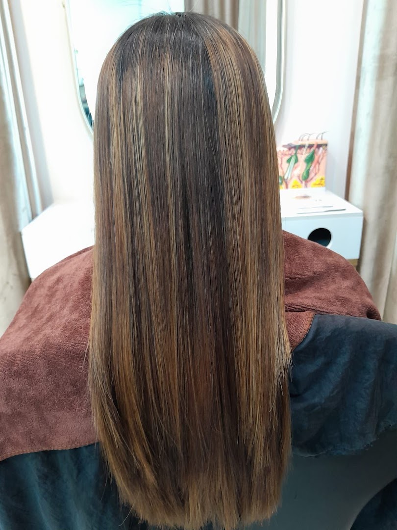 A person with long, straight, highlighted hair, showcasing a salon treatment result.
