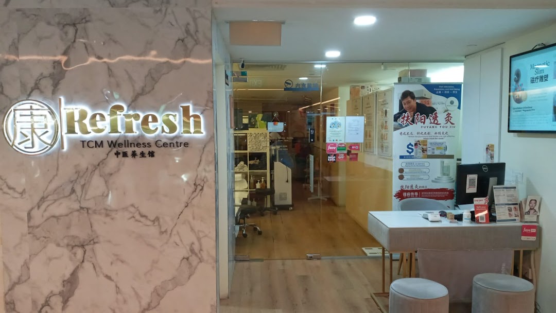 The entrance of Refresh TCM Wellness Centre, featuring a reception desk and promotional displays.