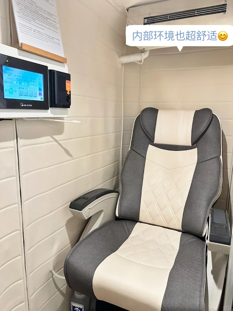 A comfortable reclining chair and control panel inside a private wellness booth.
