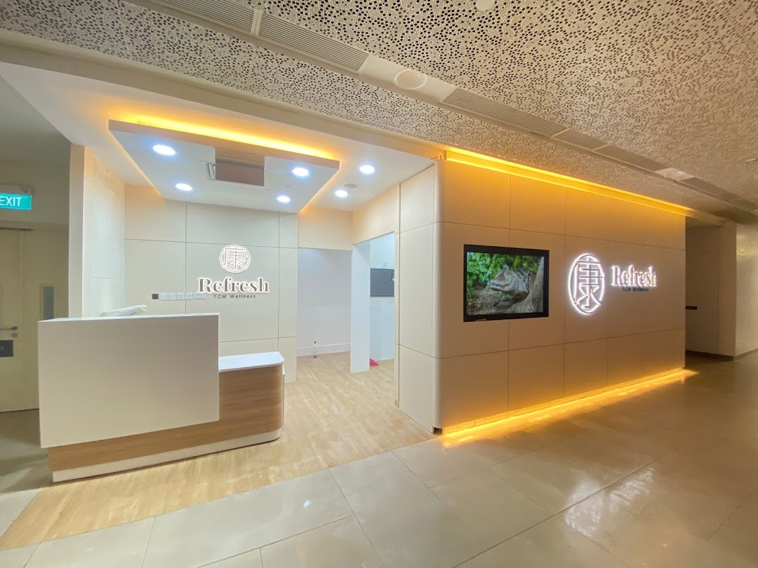 The bright and inviting entrance of Refresh TCM Wellness, featuring a reception desk and illuminated branding.