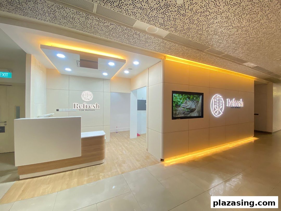 The bright and inviting entrance of Refresh TCM Wellness, featuring a reception desk and illuminated branding.
