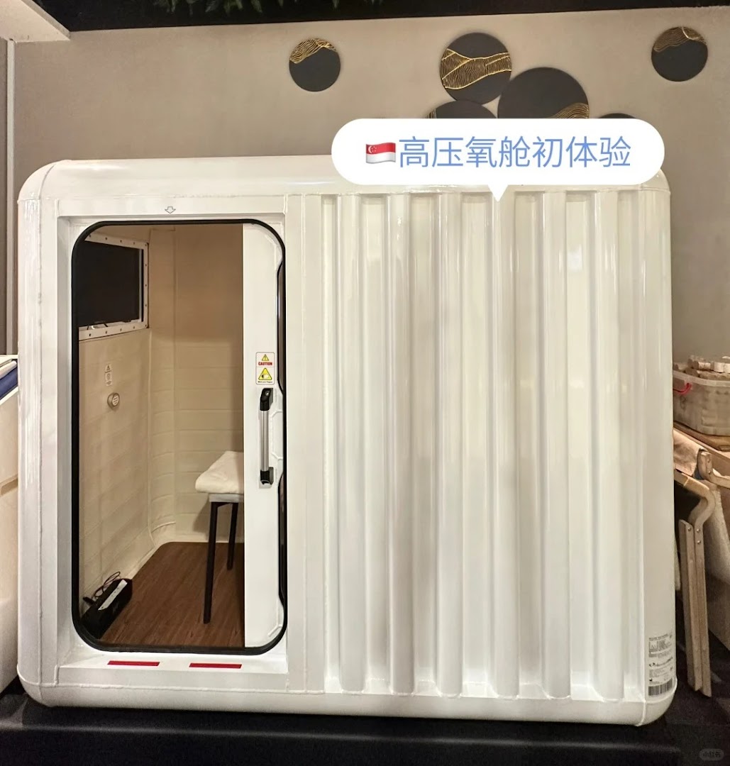 A white hyperbaric oxygen chamber with an open door, showing an interior seat.