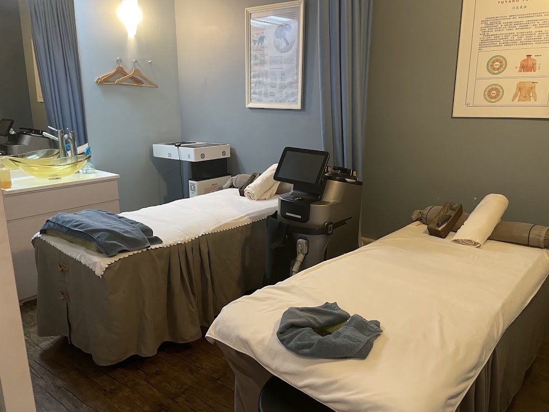 A tranquil wellness room featuring two treatment beds, modern equipment, and a soothing ambiance.