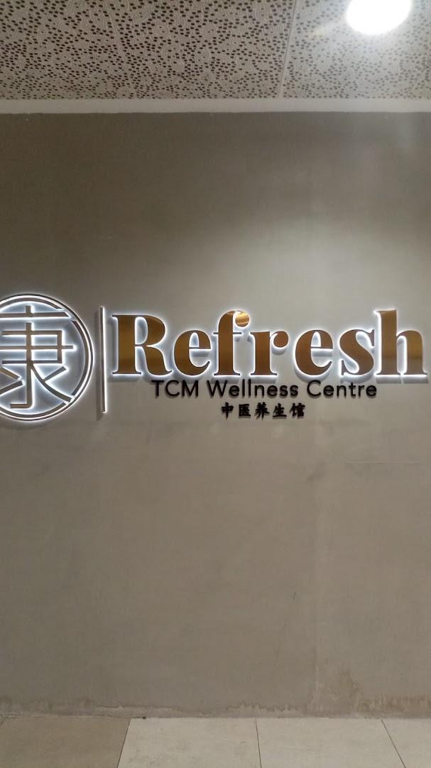 Illuminated sign for Refresh TCM Wellness Centre on a grey wall.