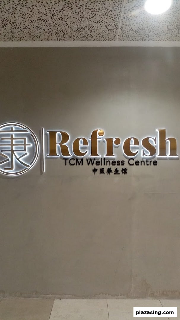 Illuminated sign for Refresh TCM Wellness Centre on a grey wall.