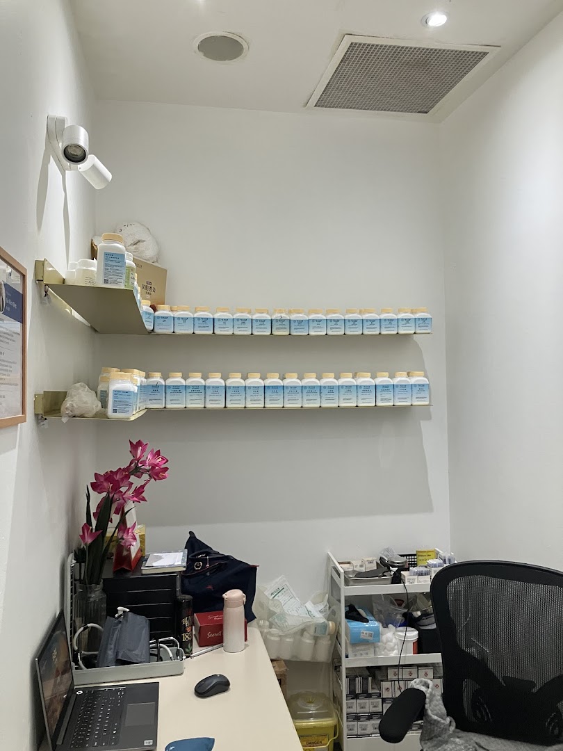 Interior view of a Refresh TCM Wellness consultation room with product shelves and a desk.