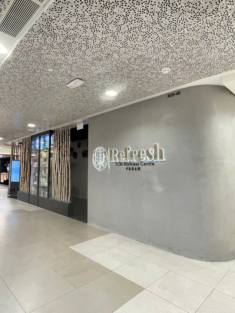 The shop front of Refresh TCM Wellness Centre, featuring its illuminated logo and display windows.