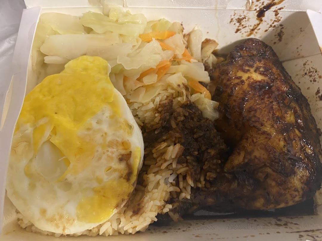 A delicious Indonesian BBQ meal in a takeout box, featuring chicken, rice, egg, and vegetables.