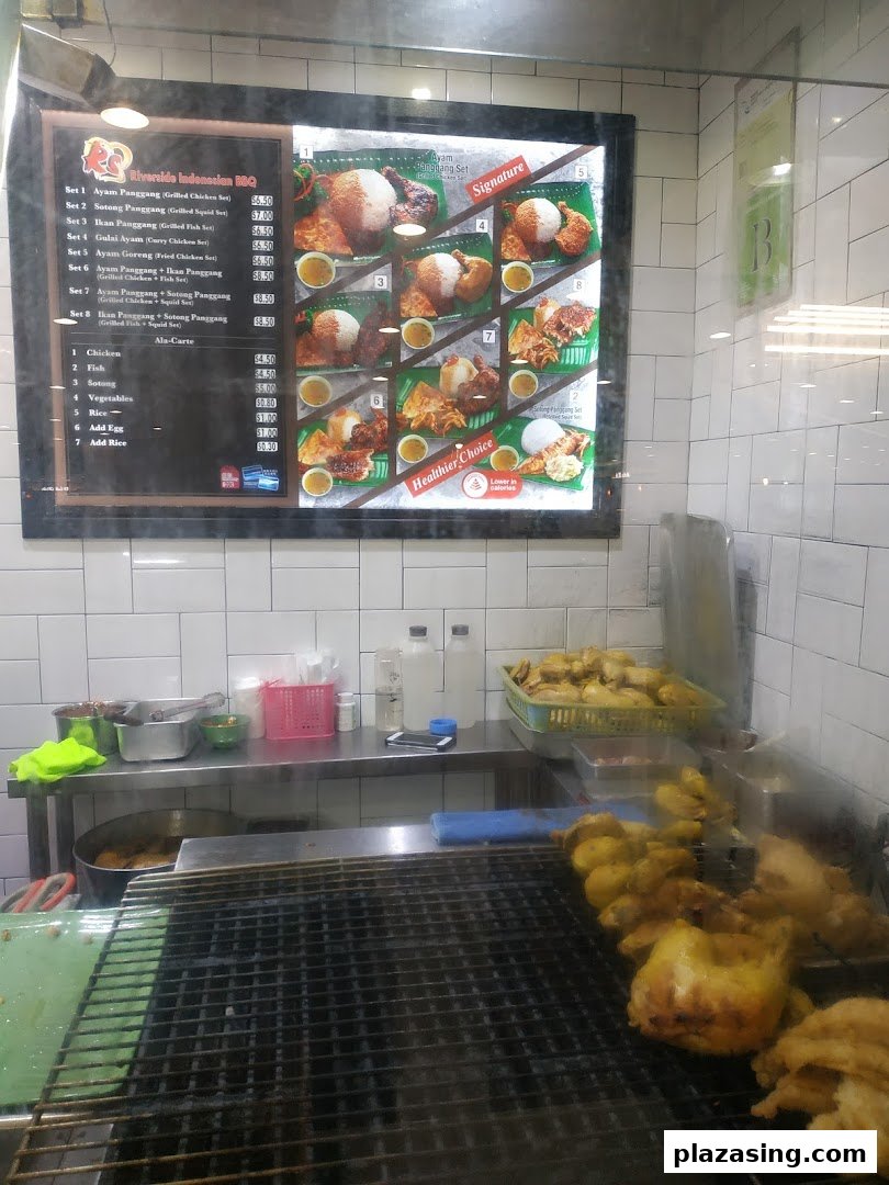 A menu board for Riverside Indonesian BBQ, showcasing various grilled and fried dishes with prices.