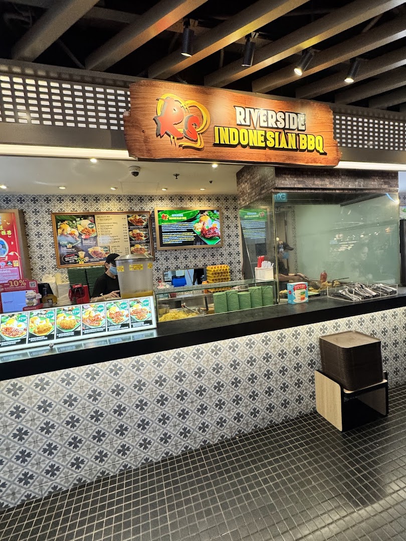 A vibrant food stall showcasing its Indonesian BBQ menu and counter service.