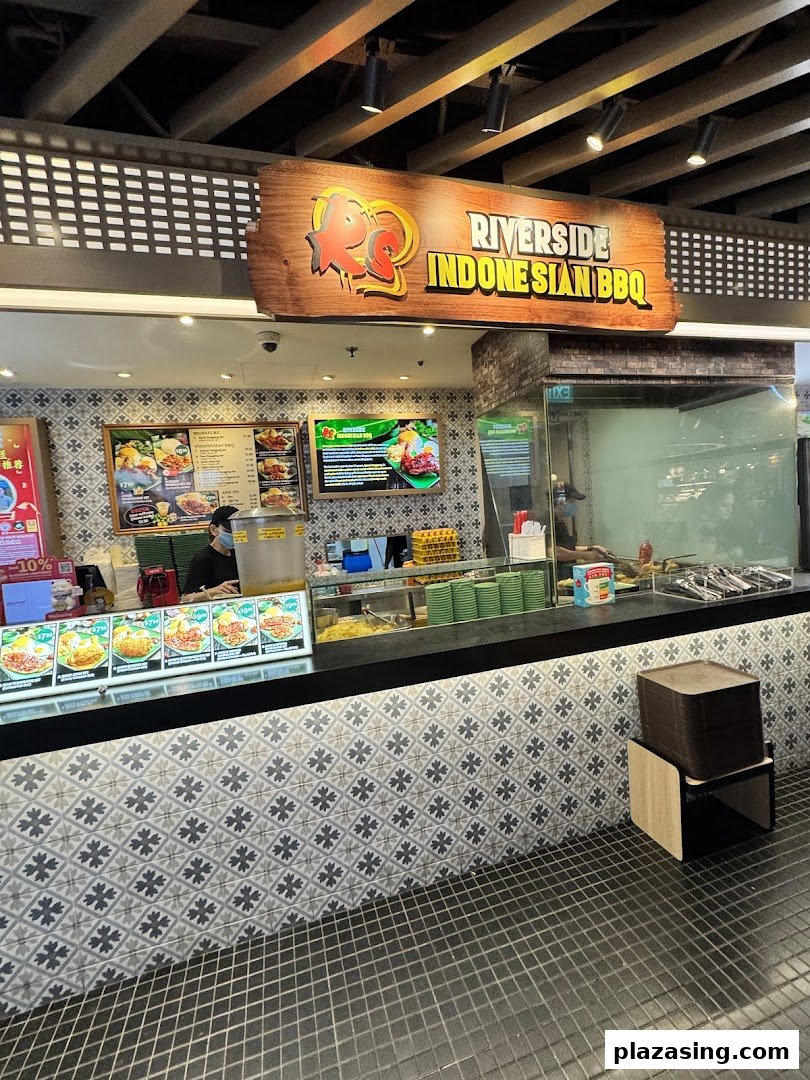 A vibrant food stall showcasing its Indonesian BBQ menu and counter service.