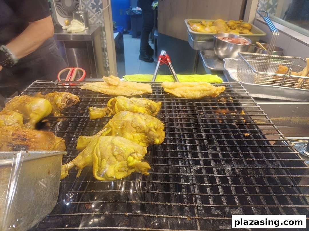 Close-up of marinated chicken and other items grilling on a barbecue at Riverside Indonesian BBQ.