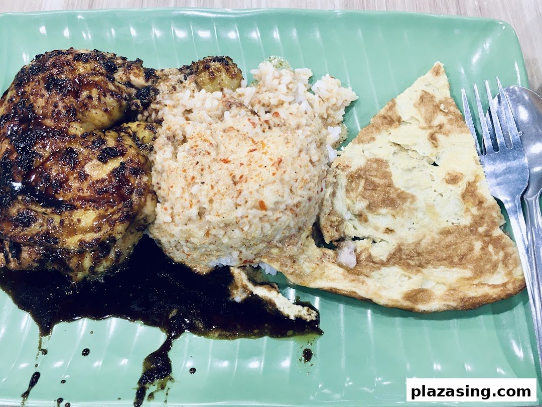 A plate of grilled chicken, spiced rice, and an omelet, served with a rich dark sauce.