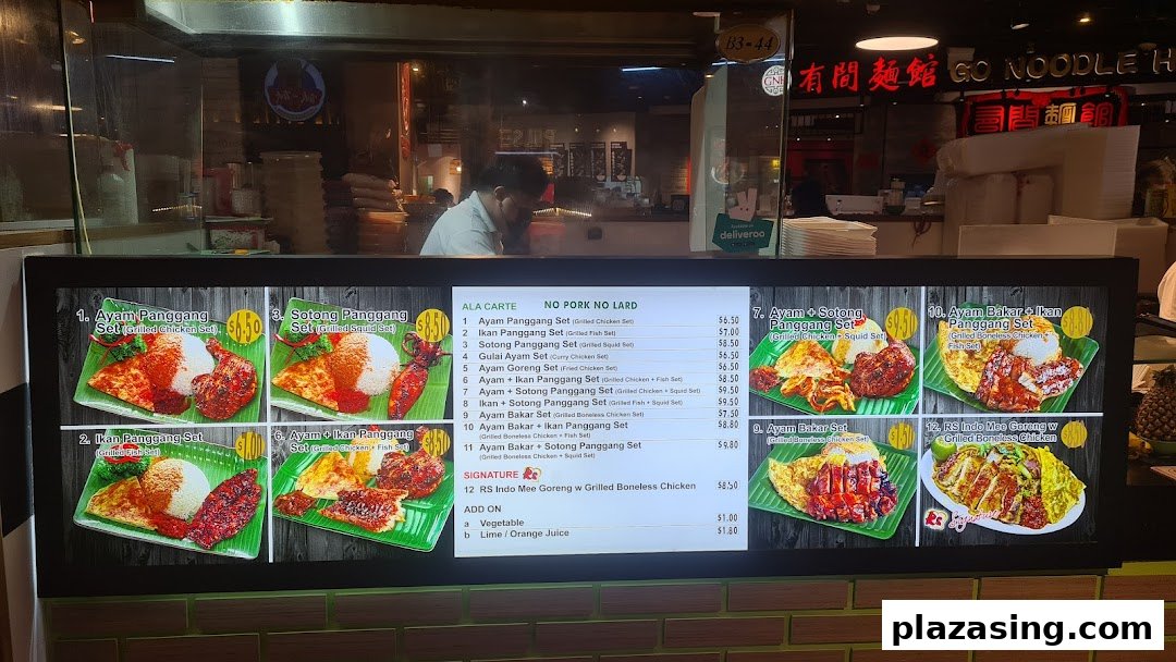 A digital menu board displaying various Indonesian BBQ sets and add-ons with prices.