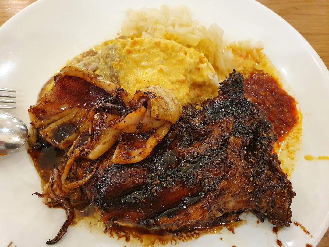A plate of grilled Indonesian BBQ chicken and squid with rice, omelette, and sambal.
