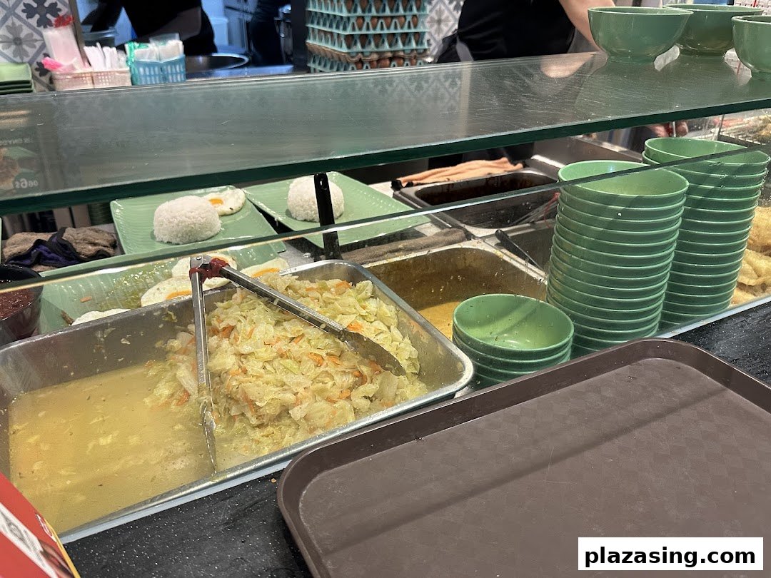 A vibrant food counter showcasing fresh Indonesian dishes like rice, eggs, and vegetables.