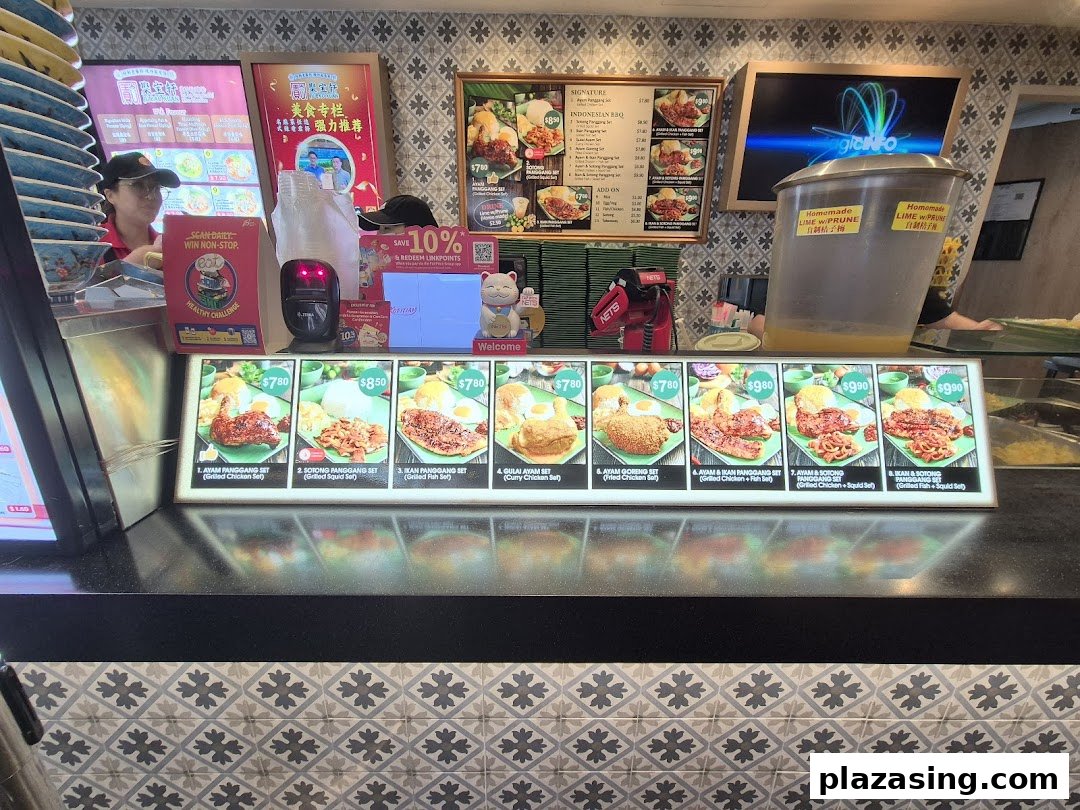 A food stall counter displaying various Indonesian BBQ dishes and menu items with prices.