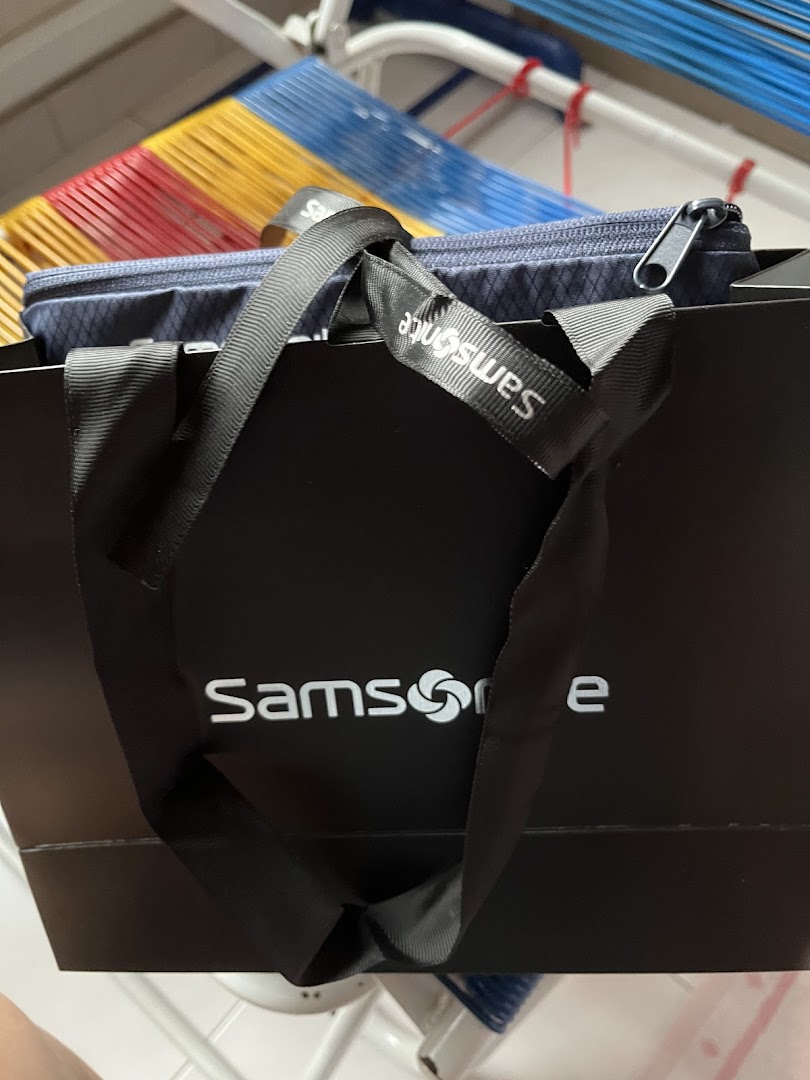 A Samsonite shopping bag with a blue patterned pouch visible inside, showcasing a recent purchase.