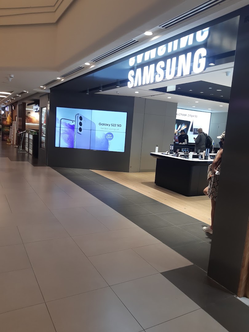 The entrance of a Samsung Service Centre with a large display showing a Galaxy S22 5G promotion.