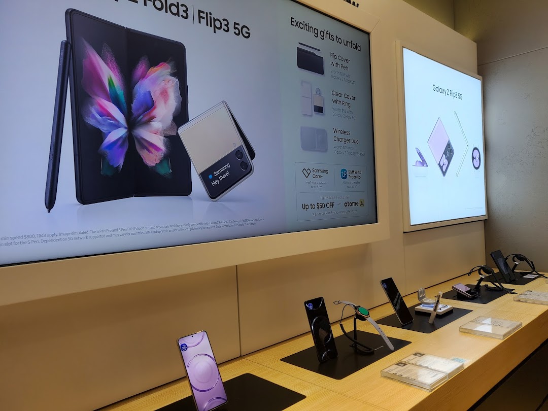 An interior view of a Samsung Service Centre showcasing Galaxy Z Fold3, Flip3 5G, and various accessories on display.