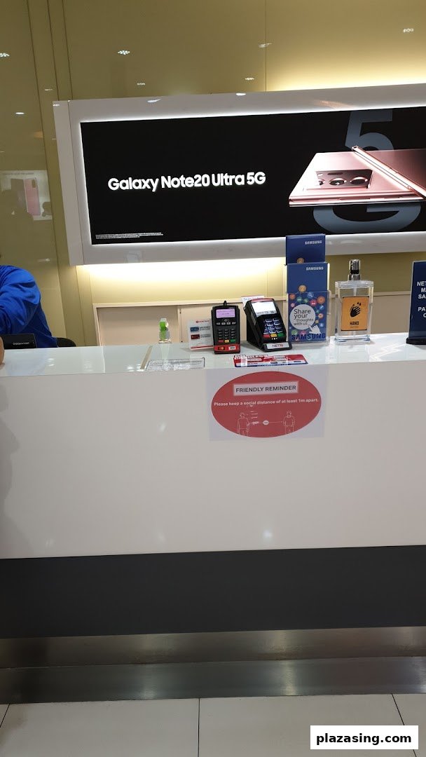 A Samsung Service Centre counter featuring a Galaxy Note20 Ultra 5G display and payment terminals.