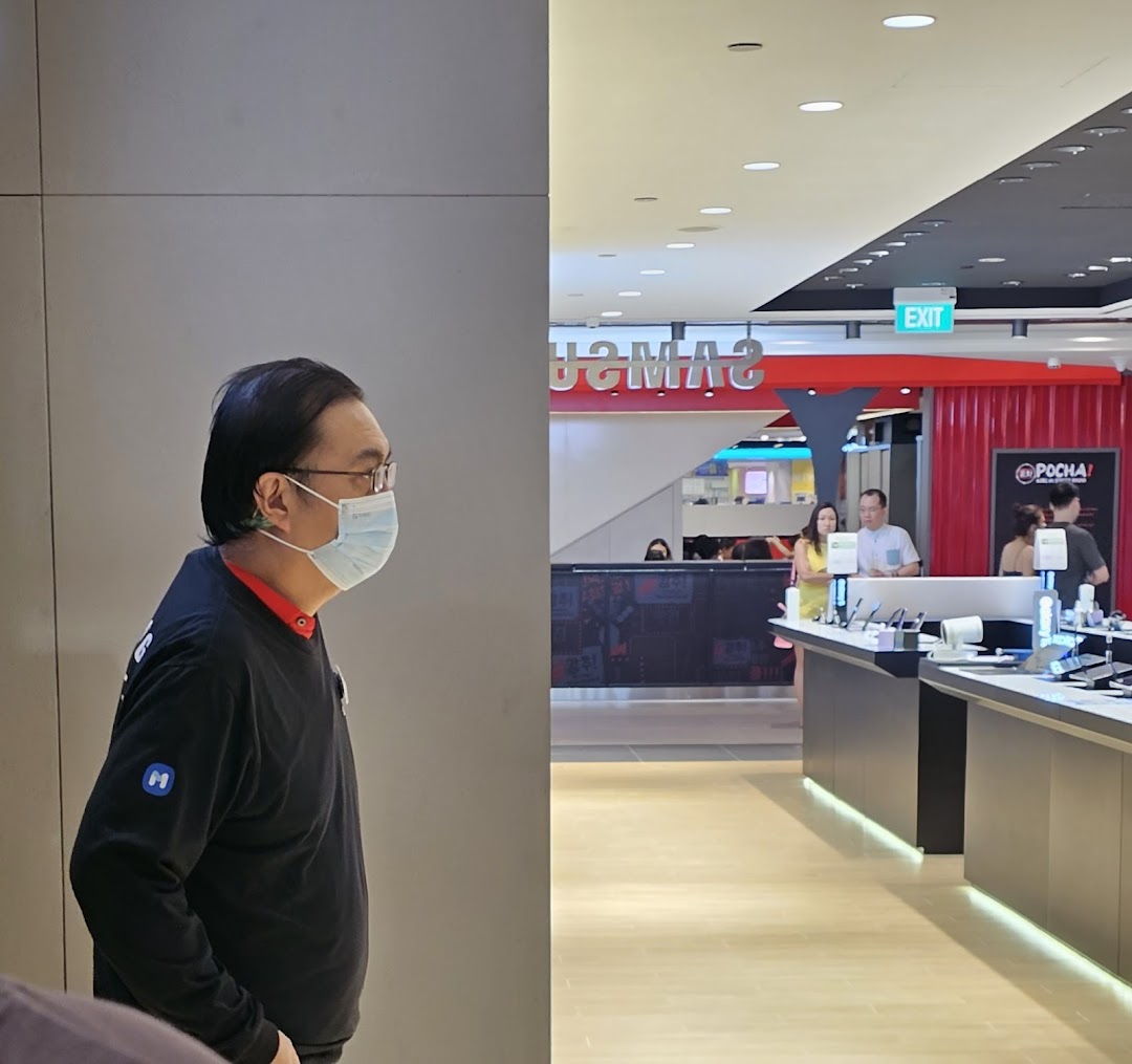 Interior view of a Samsung Service Centre with staff and product displays.