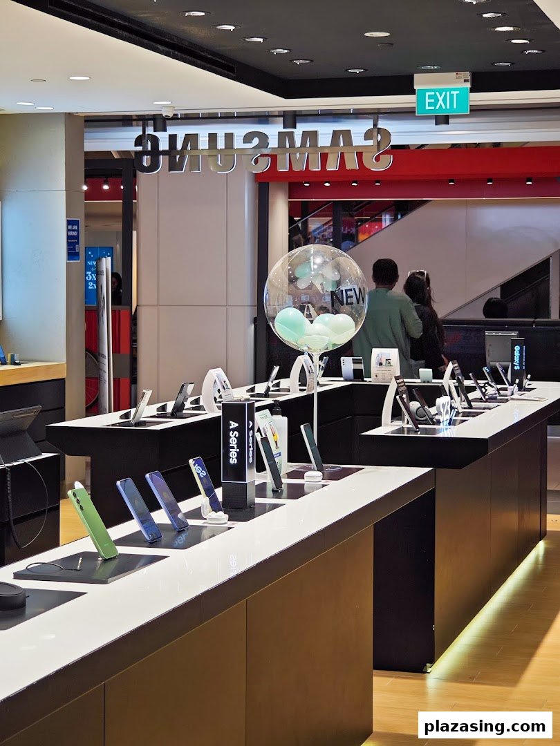 Interior view of a Samsung store showcasing various mobile devices and accessories on display tables.