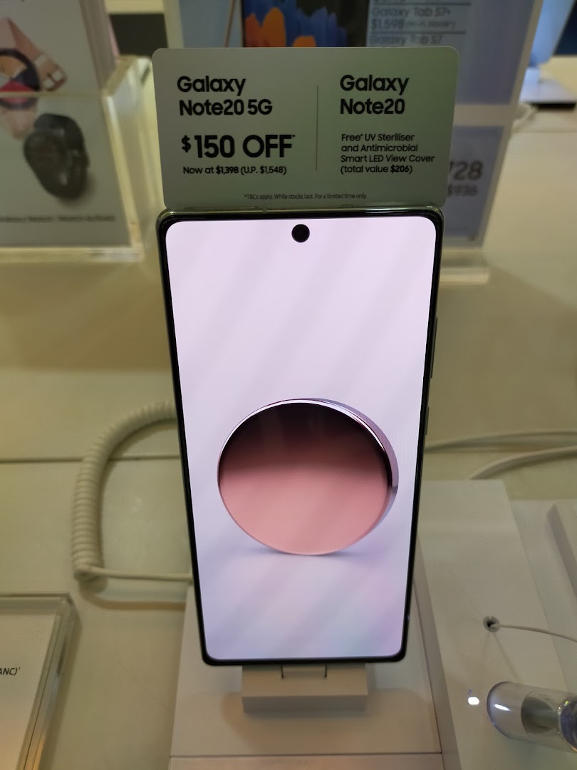 A Samsung Galaxy Note20 5G smartphone on display with promotional offers in a Samsung store.