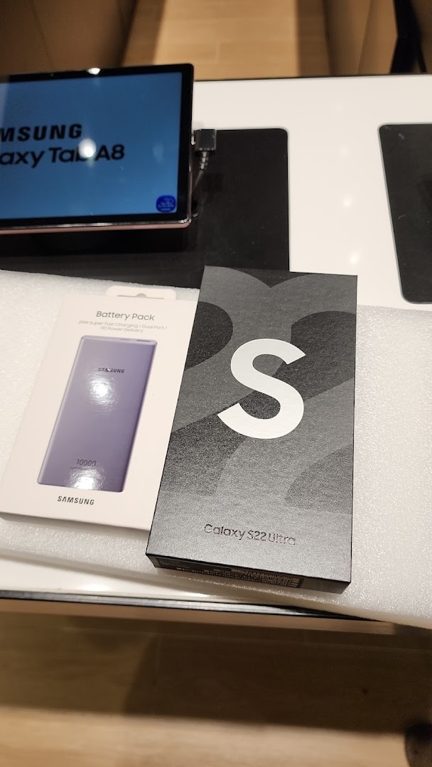 Samsung Galaxy Tab A8, Battery Pack, and S22 Ultra box displayed in a Samsung Service Centre.