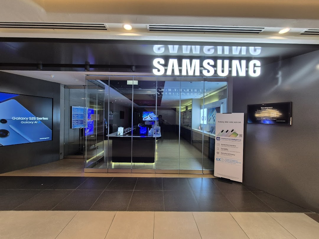 Exterior view of a Samsung Service Centre with illuminated signage and promotional displays for Galaxy devices.