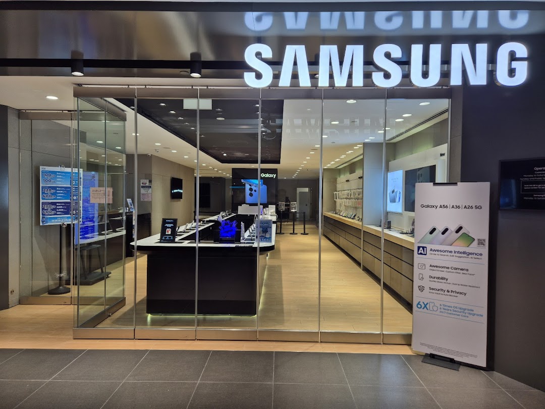 The illuminated entrance of a Samsung Service Centre showcasing various devices and service information.