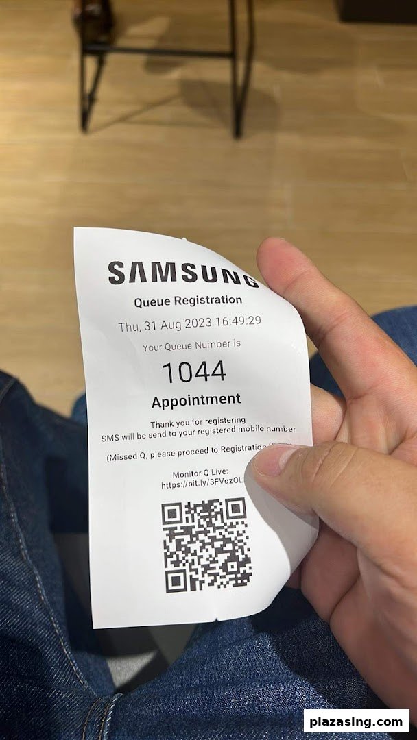 A person holds a Samsung Service Centre queue registration ticket with number 1044.