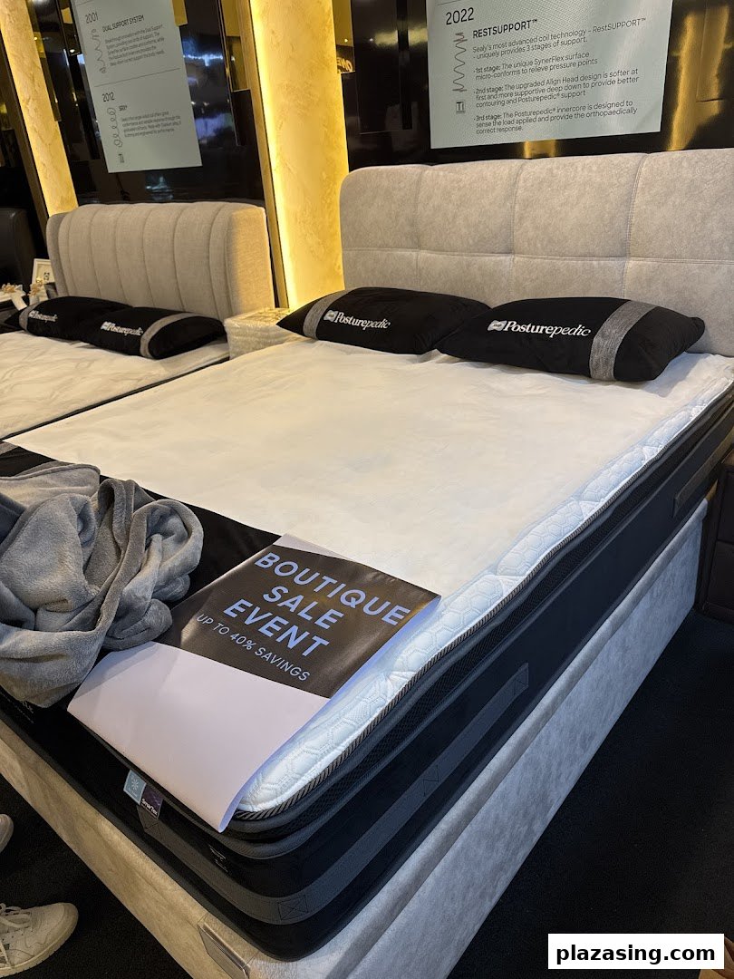 An interior view of Sealy Sleep Boutique showcasing mattresses and beds, with a 'Boutique Sale Event' sign.