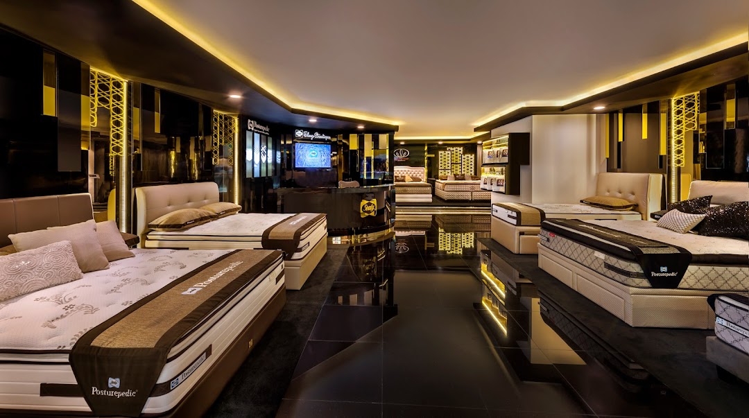 An elegant interior view of Sealy Sleep Boutique showcasing various mattresses and beds in a well-lit showroom.