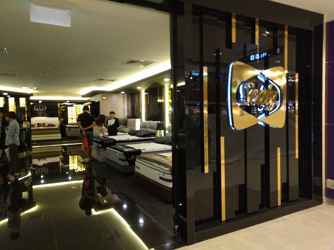 The Sealy Sleep Boutique entrance features a prominent gold logo, inviting customers into a showroom displaying various mattresses.
