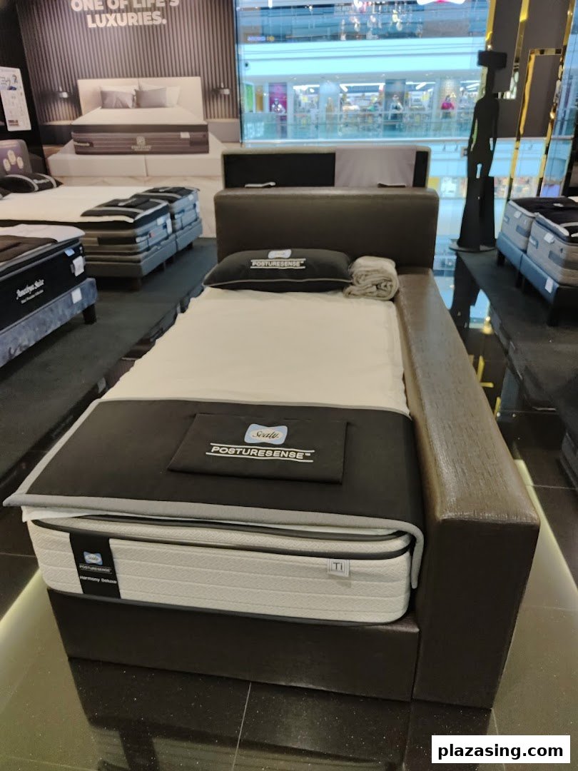 A display of a Sealy Posturepedic mattress and bed frame inside the Sealy Sleep Boutique showroom.
