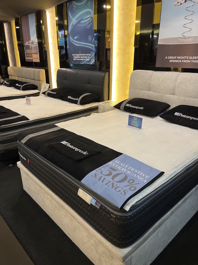 An interior view of Sealy Sleep Boutique showcasing various Posturepedic mattresses and beds on display.