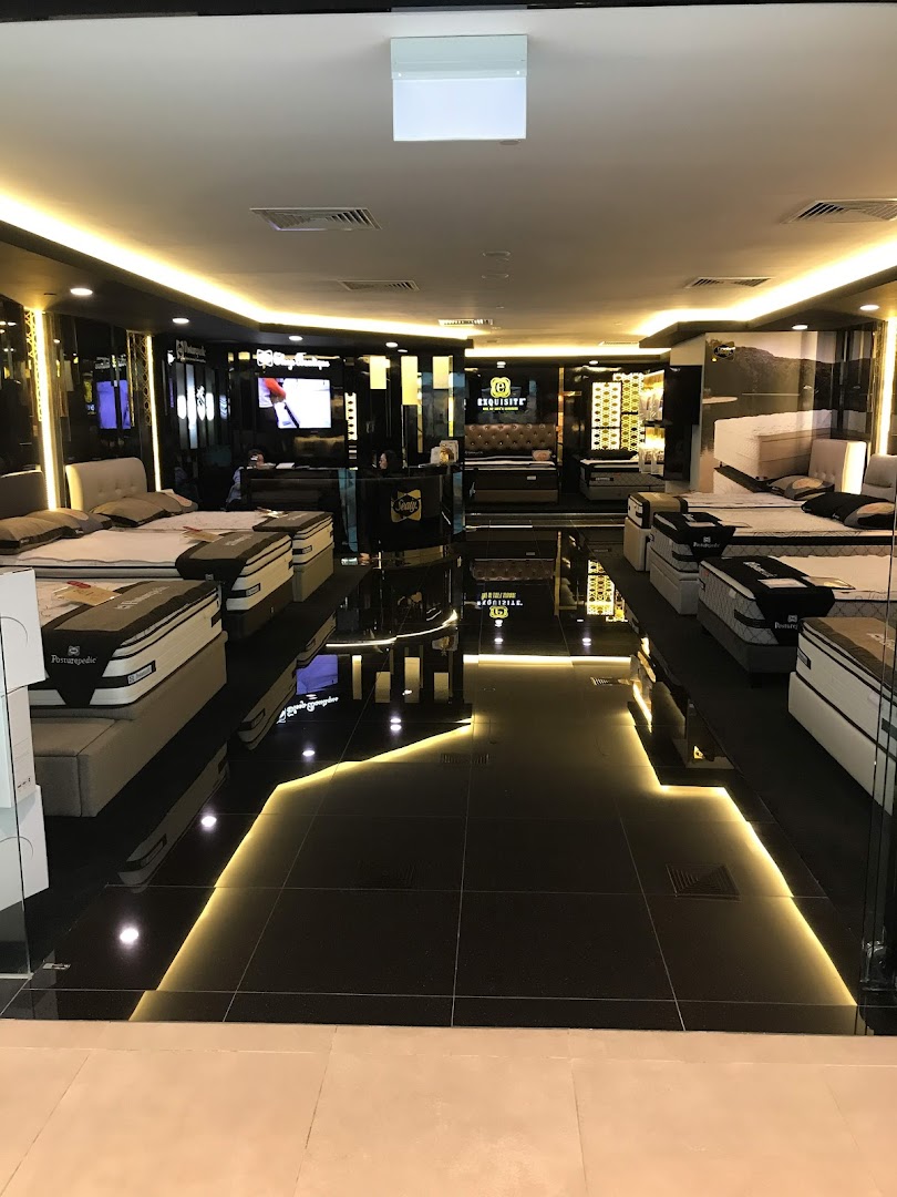 A luxurious interior view of Sealy Sleep Boutique, showcasing various mattresses and beds in a well-lit showroom.