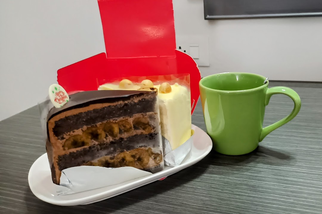 Two delicious cake slices, one chocolate and one light-colored, next to a green mug.
