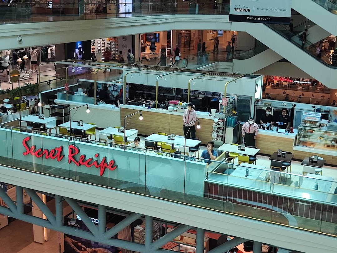 An aerial view of Secret Recipe restaurant's interior with dining tables and staff in a bustling mall.