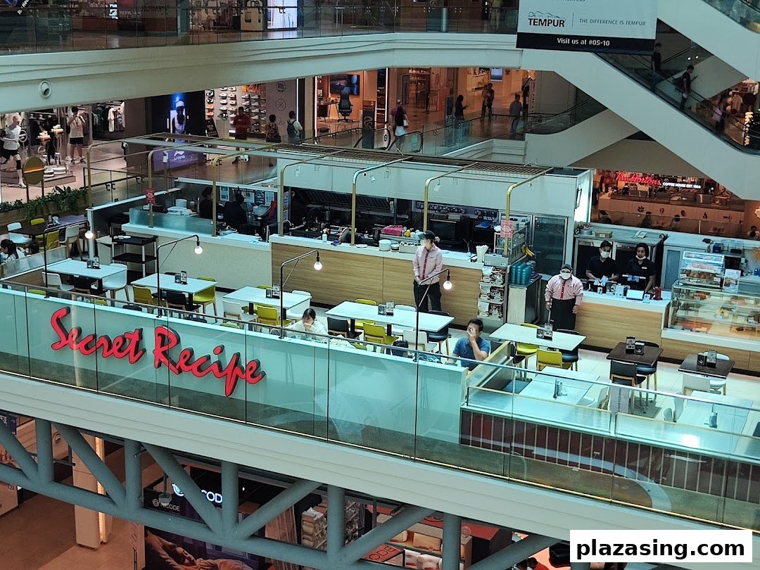 An aerial view of Secret Recipe restaurant's interior with dining tables and staff in a bustling mall.