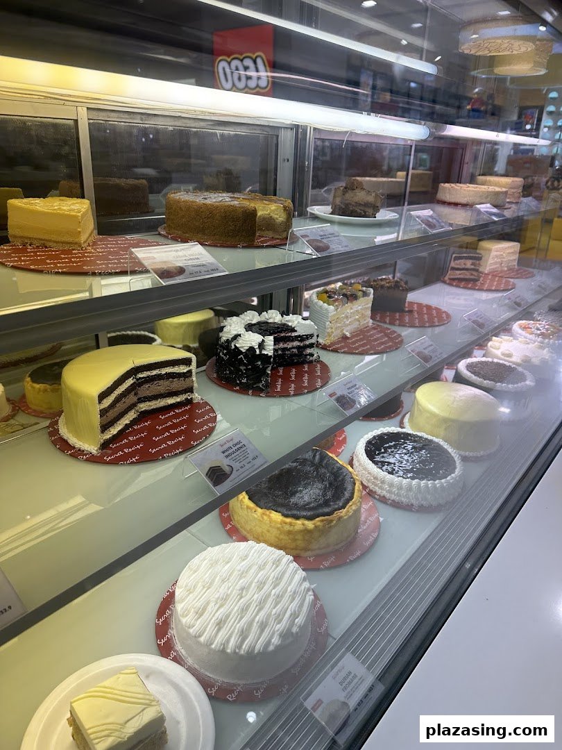A vibrant display case showcasing a wide variety of delicious cakes and cheesecakes at Secret Recipe.